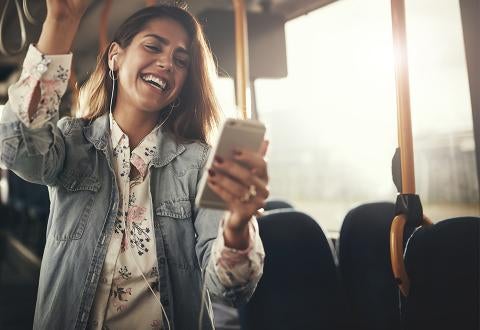 Woman smiling at phone on bus